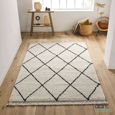 une photo d'un tapis noir et blanc dans un coin d'une pièce