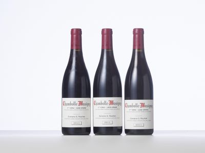 three bottles of red wine sitting on top of a white table