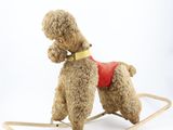 a brown teddy bear on a rocking horse on a white background