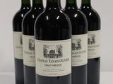 four bottles of red wine are lined up on a white surface