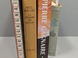 three books that are sitting on a white table