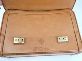 tan leather briefcase with two gold - plated cufflinks on it