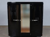 a black cabinet with two doors and a mirror on top of it