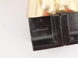 a gold statue of a woman on a black base