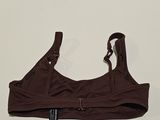 a close up of a brown bra top on a white surface