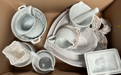 a lot of white dishes and cups in a box