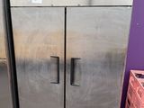 two stainless steel refrigerators sitting next to each other in a room