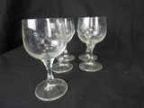 three empty wine glasses sitting on a black table