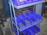 un chariot bleu sur lequel sont posés des bacs bleus, dans un garage