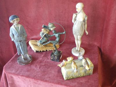 three figurines sitting on a table with a red cloth