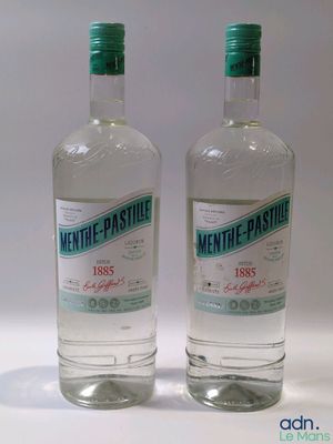 deux bouteilles d'alcool posées l'une à côté de l'autre sur une surface blanche