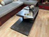 une table basse sur laquelle est posé un livre, devant un canapé
