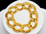 bracelet plaqué or sur une assiette blanche avec un fond noir