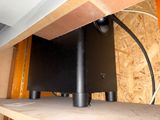 a picture of a black speaker on a wooden shelf