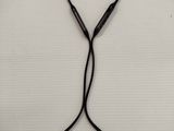 a close up of a pair of black ear buds on a white surface