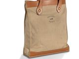 Le sac fourre-tout en toile avec des anses en cuir est de couleur beige et marron