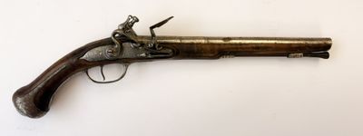 un vieux pistolet avec une poignée en bois sur une surface blanche