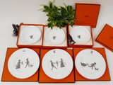 four plates with black and white designs on them in a box
