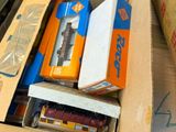 a cardboard box full of different types of toy trains