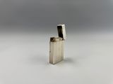 un gros plan d'un briquet posé sur une surface blanche, avec un arrière-plan gris