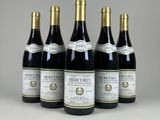 quatre bouteilles de vin sont alignées sur une table
