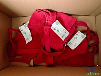une boîte sur laquelle sont posés un sac rouge et deux étiquettes