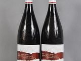 two bottles of wine sitting on top of a table next to each other