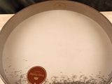 une assiette sur laquelle est collé un autocollant, posée sur une table