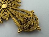 gold filigree pendant with filigrees and filigrees on a white surface