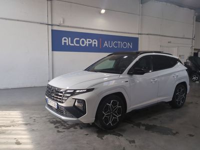 Le SUV blanc est garé dans un garage où se trouve une enseigne bleue et blanche.