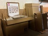 un ordinateur portable posé sur un bureau, entouré de cartons