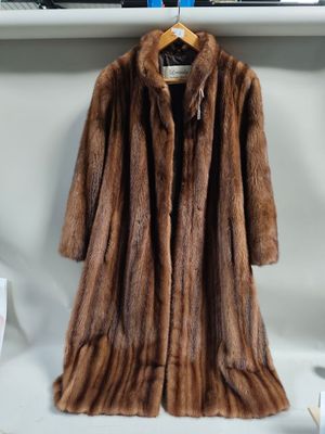 a brown fur coat hanging on a rack in a room