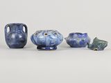 three blue vases and a small vase sitting on a white surface