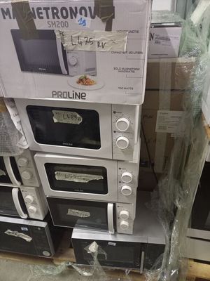 une pile de fours à micro-ondes exposés dans un magasin