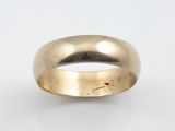 gros plan d'une bague en or sur une surface blanche
