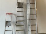 several ladders are leaning against a white wall in a room
