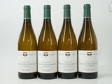 trois bouteilles de vin blanc sont alignées sur une surface blanche