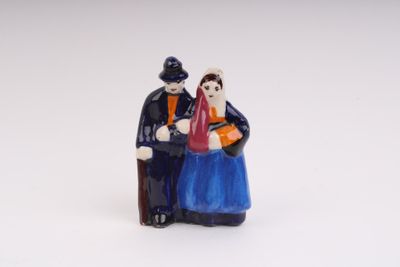 a figurine of a man and a woman sitting on a bench