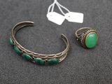 a close up of a bracelet and a ring on a table