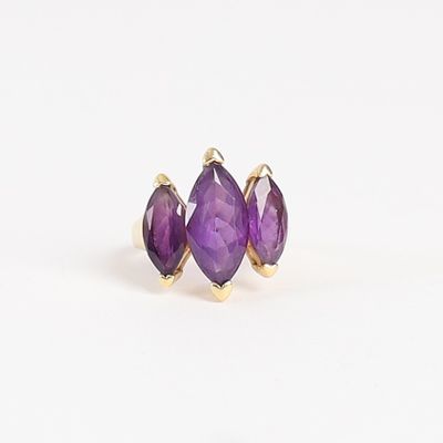 un gros plan sur une paire de boucles d'oreilles en pierre violette posées sur une surface blanche