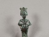 une ancienne statue en bronze représentant une femme avec un chat assis sur ses genoux