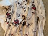 an image of a white shirt with red and black flowers on it