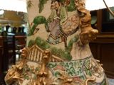 a vase with a painting on it sitting on a table