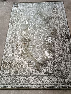 Un vieux tapis est posé par terre au milieu de la pièce.