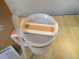 a person holding a plastic cup with a wooden spoon in it