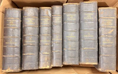 several old books are in a cardboard box on a table