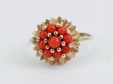 un gros plan d'une bague en or ornée de perles rouges