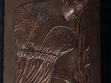 a bronze plaque of a woman holding a baby
