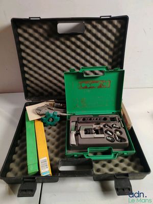 une mallette verte contenant des outils, posée sur une table