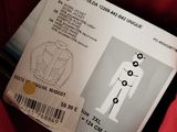 a red jacket with a label on it and a pair of scissors
